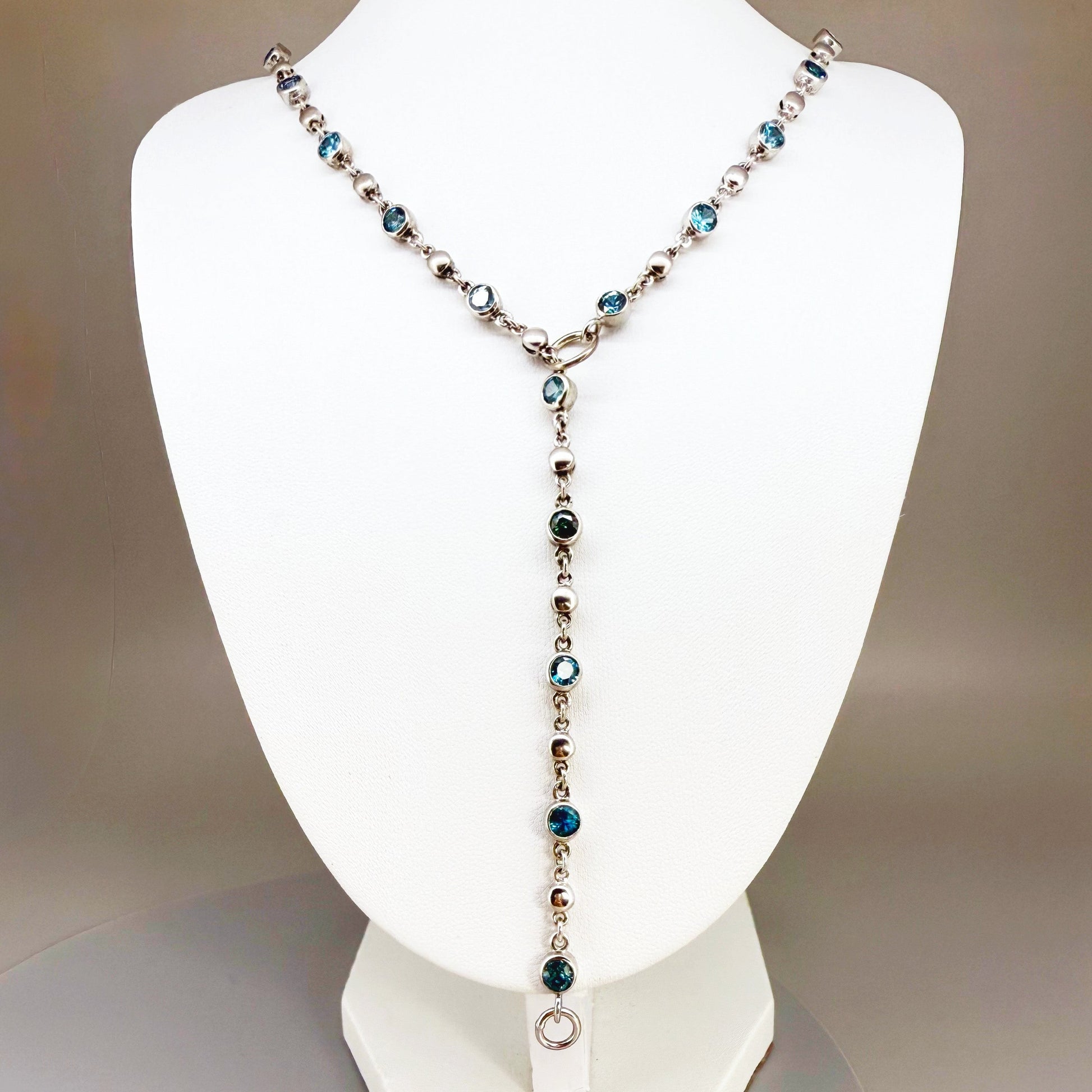Handcrafted zircon necklace (19 ct) with adjustable loop clasp, wearable along the back or décolleté, white-gold-plated silver.