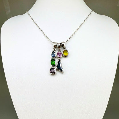 Handcrafted three-pendant gemstone necklace with sapphires, ruby, spinel, and tsavorite (5.81 ct total) on a black leather cord — modular design in white-gold-plated silver.