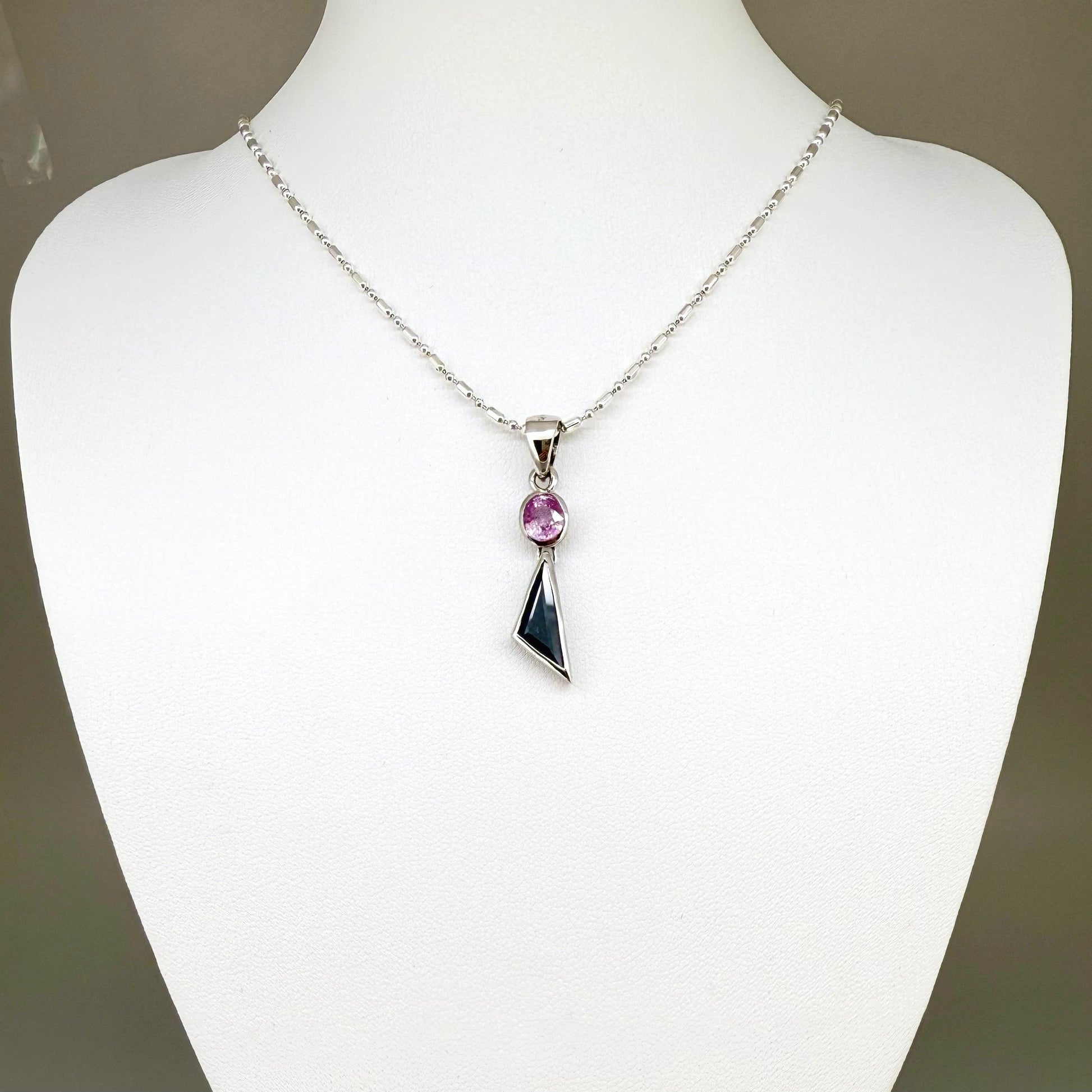 Handcrafted three-pendant gemstone necklace with sapphires, ruby, spinel, and tsavorite (5.81 ct total) on a black leather cord — modular design in white-gold-plated silver.