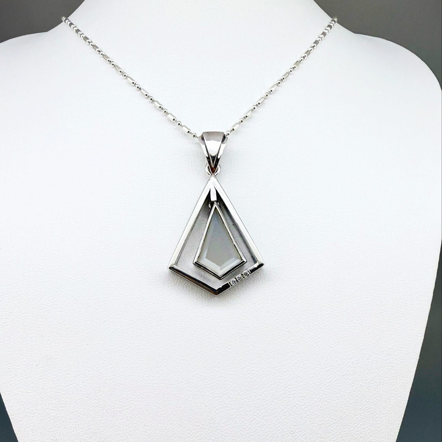 Handcrafted white gold-plated silver pendant with 4.04 ct moonstone and cubic zirconia accents in a geometric design.
