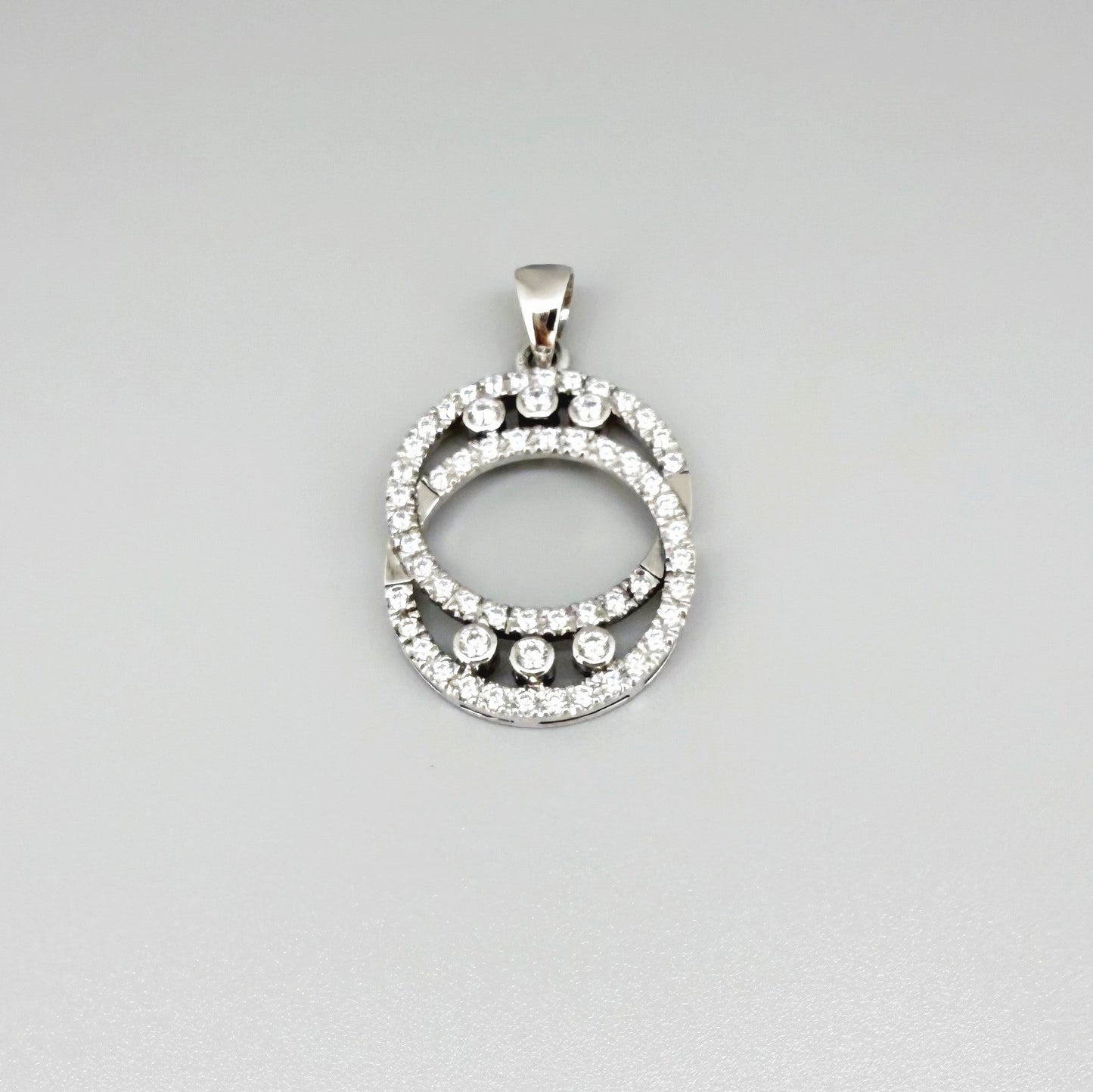 Handcrafted round pendant with cubic zirconia set in white-gold-plated sterling silver.