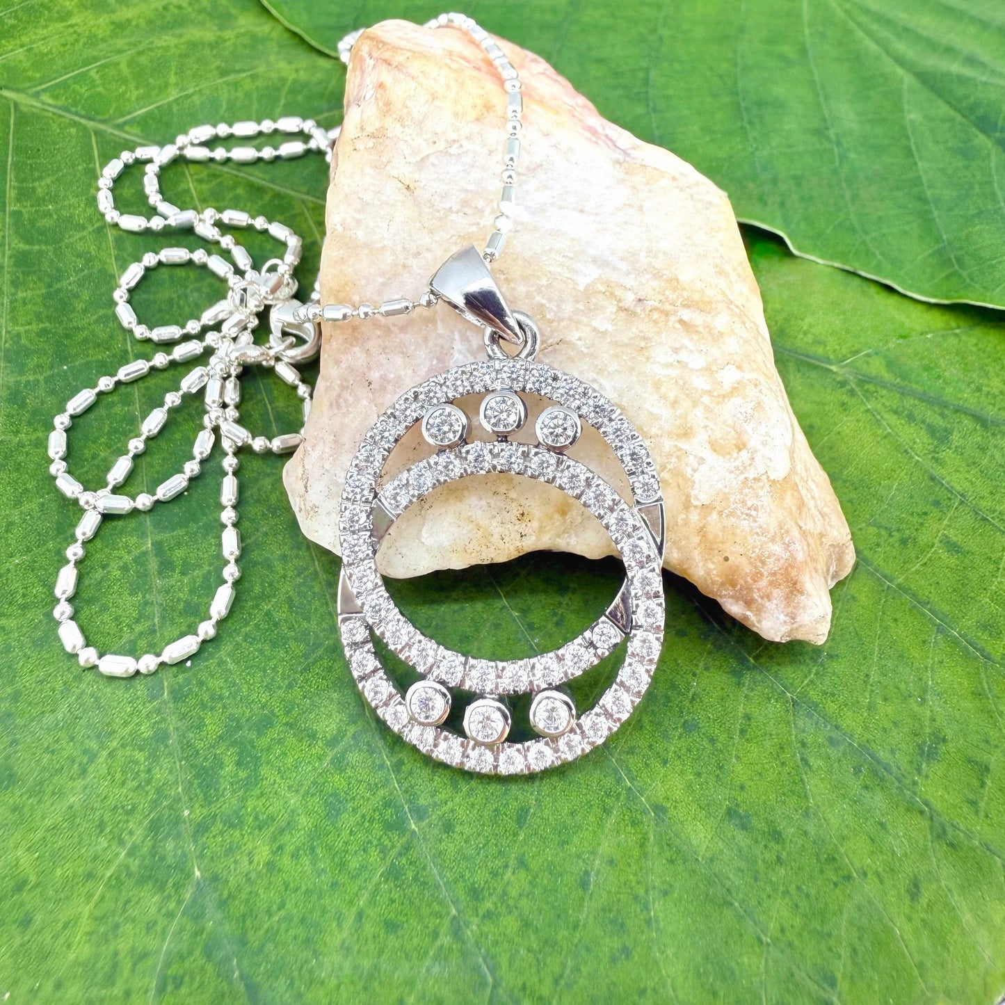 Handcrafted round pendant with cubic zirconia set in white-gold-plated sterling silver.