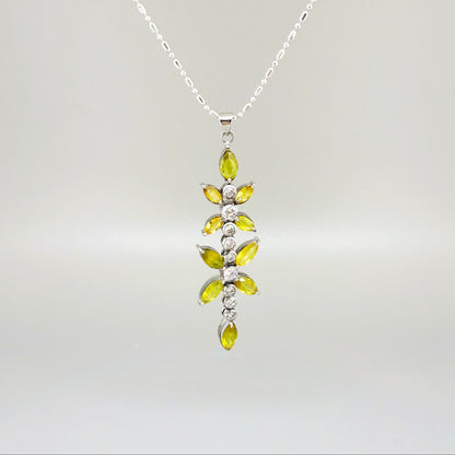Handcrafted pendant with natural yellow sapphires (7.37 ct) and cubic zirconia in white-gold-plated silver leaf design, shown with matching earrings.