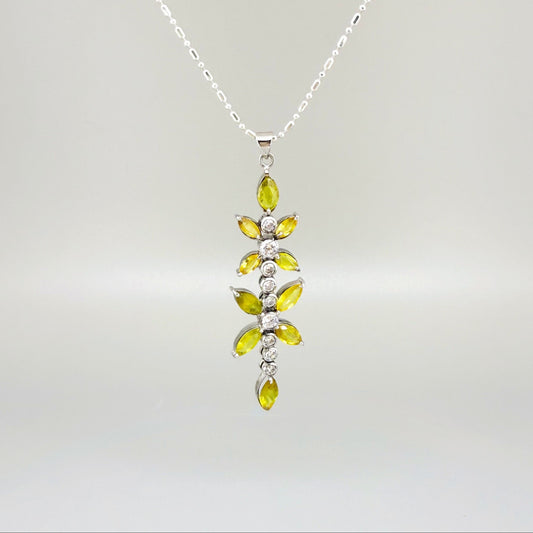 Handcrafted pendant with natural yellow sapphires (7.37 ct) and cubic zirconia in white-gold-plated silver leaf design, shown with matching earrings.