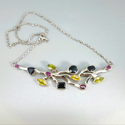 Handmade necklace in white-gold-plated silver featuring 13.89 ct natural sapphires and tourmalines in multicolor hues — artistic design with integrated chain.
