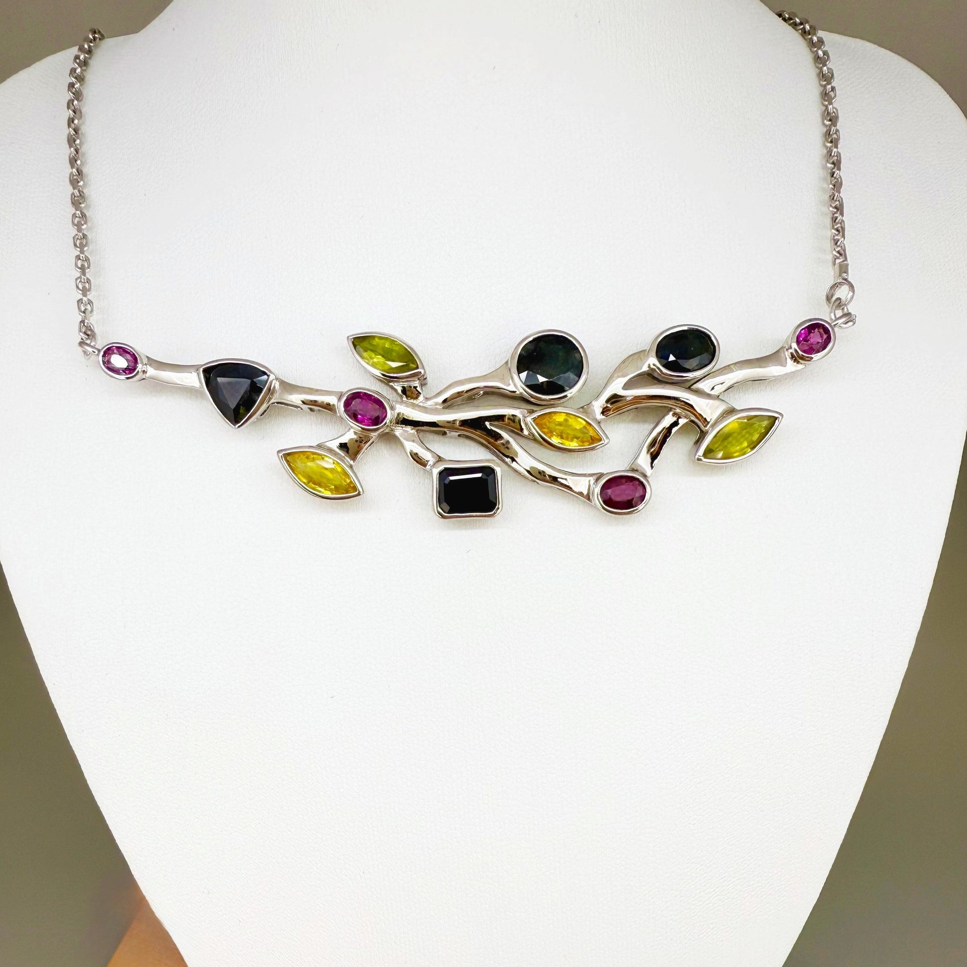 Handmade necklace in white-gold-plated silver featuring 13.89 ct natural sapphires and tourmalines in multicolor hues — artistic design with integrated chain.