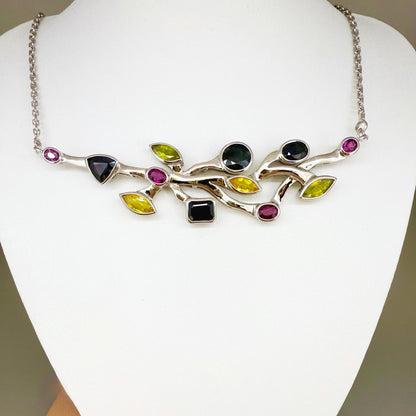 Handmade necklace in white-gold-plated silver featuring 13.89 ct natural sapphires and tourmalines in multicolor hues — artistic design with integrated chain.