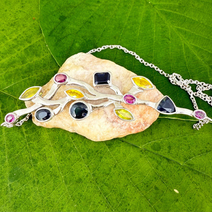 Handmade necklace in white-gold-plated silver featuring 13.89 ct natural sapphires and tourmalines in multicolor hues — artistic design with integrated chain.