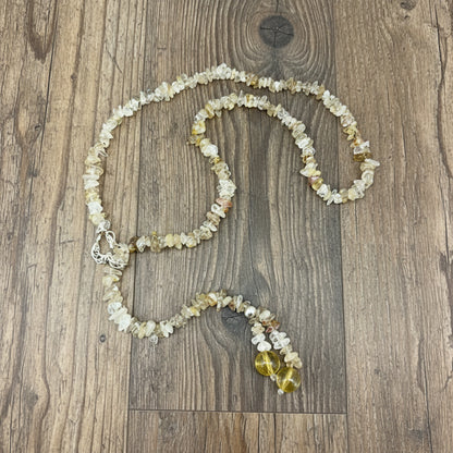 Golden rutilated quartz necklace with polished beads and a stainless-steel loop closure, styled as a drop-through design.