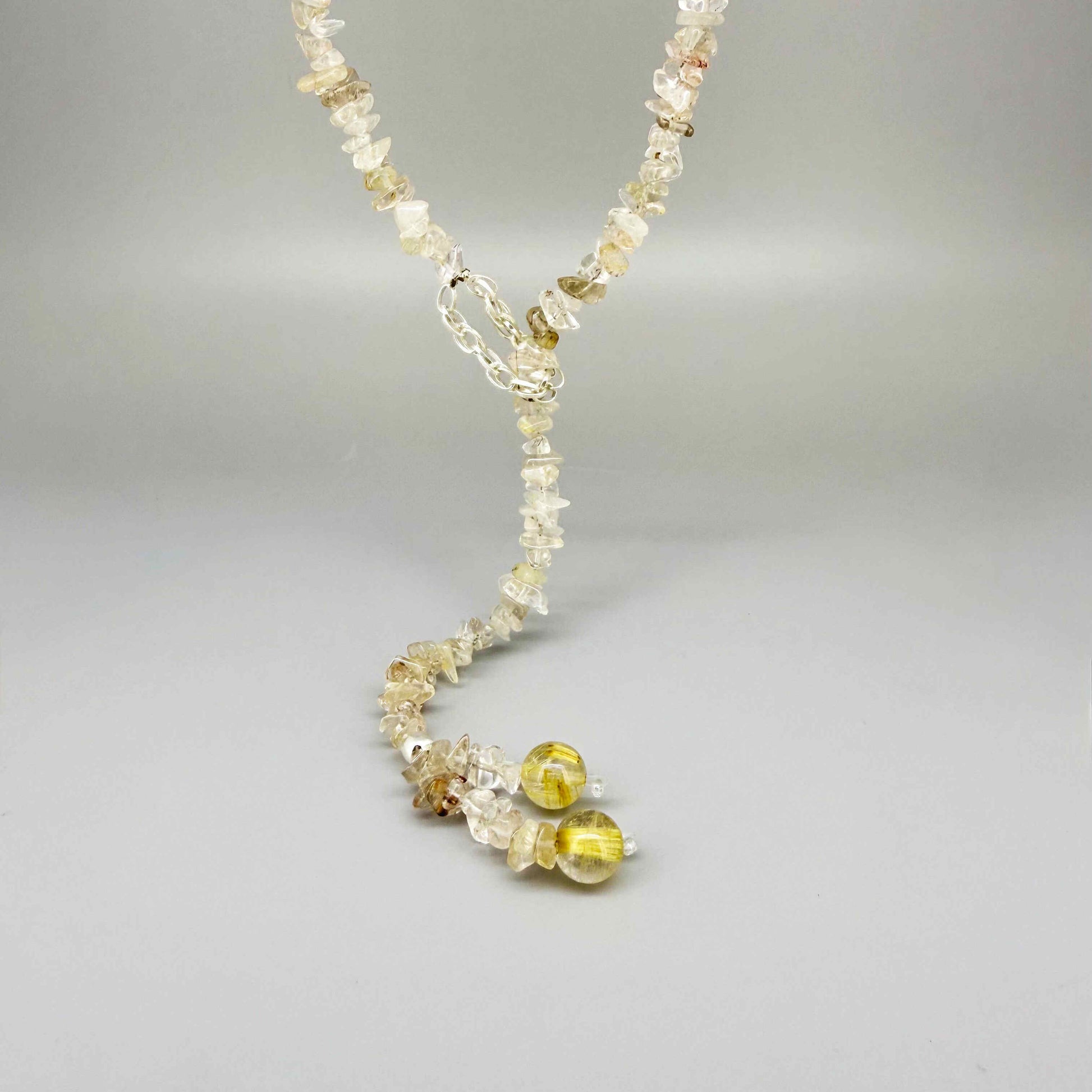 Golden rutilated quartz necklace with polished beads and a stainless-steel loop closure, styled as a drop-through design.