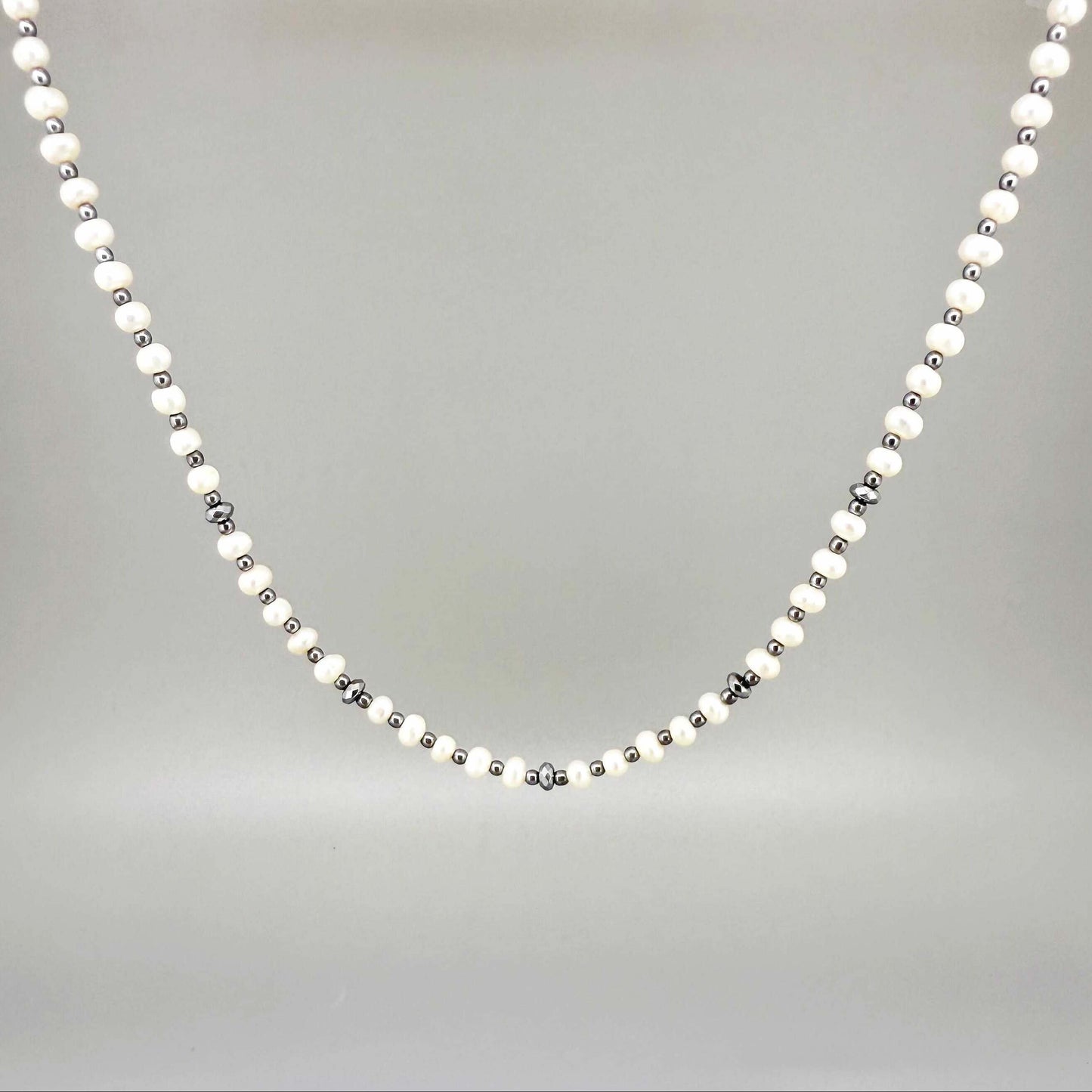Cultivated Pearl and hematite necklace, 46 cm / 18.1 in long, featuring alternating white pearls and metallic grey hematite beads.
