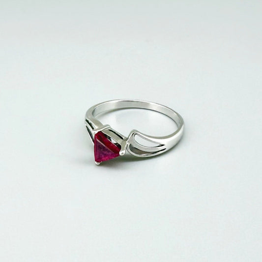 Ruby triangle-cut ring in white gold plated sterling silver, featuring a vivid red natural gemstone in a modern geometric solitaire design.