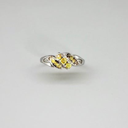 White gold plated sterling silver ring featuring two marquise-cut yellow sapphires in an elegant bypass setting.