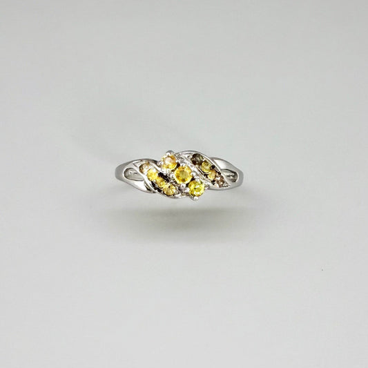 White gold plated sterling silver ring featuring two marquise-cut yellow sapphires in an elegant bypass setting.