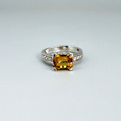Citrine and CZ ring in white gold plated sterling silver, featuring a faceted golden gemstone framed by clear cubic zirconia, elegant and radiant design.