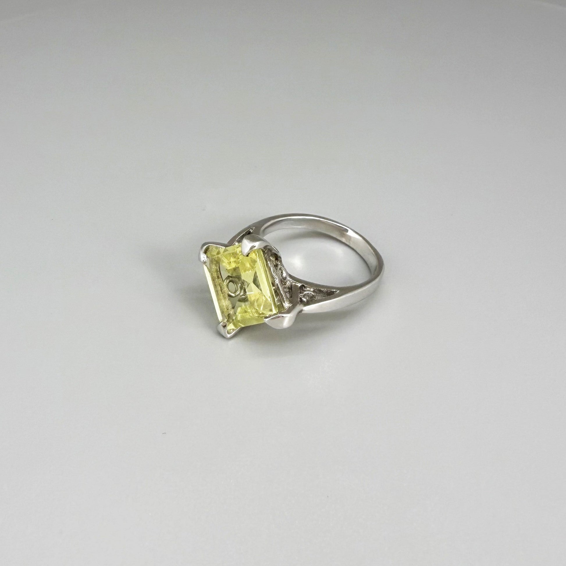 Lemon quartz solitaire ring in white gold plated sterling silver, featuring a rectangular faceted yellow gemstone, elegant and timeless design.