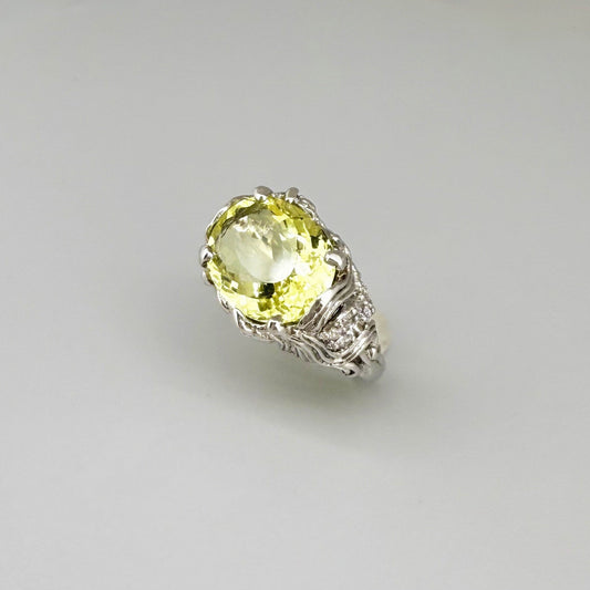 Lemon quartz ring in white gold plated sterling silver, featuring a faceted oval-cut yellow-green gemstone in an ornate vintage-inspired setting.