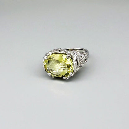 Lemon quartz ring in white gold plated sterling silver, featuring a faceted oval-cut yellow-green gemstone in an ornate vintage-inspired setting.