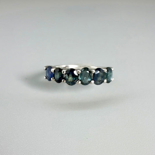 Blue sapphire ring in white gold plated sterling silver on neutral background