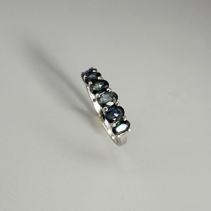 Blue sapphire ring in white gold plated sterling silver on neutral background