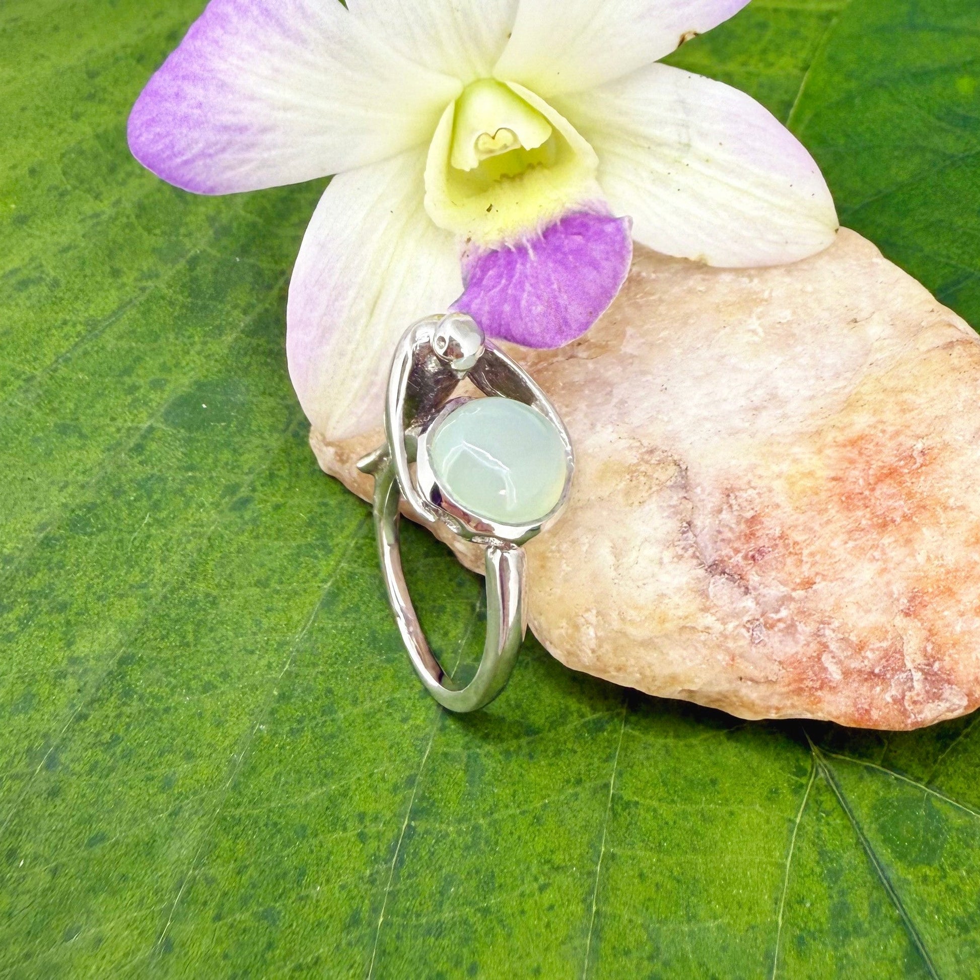 Handcrafted sterling silver ring with bird motif, featuring a 4.76 ct chalcedony cabochon resembling water in a fountain.