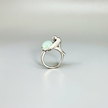 Handcrafted sterling silver ring with bird motif, featuring a 4.76 ct chalcedony cabochon resembling water in a fountain.