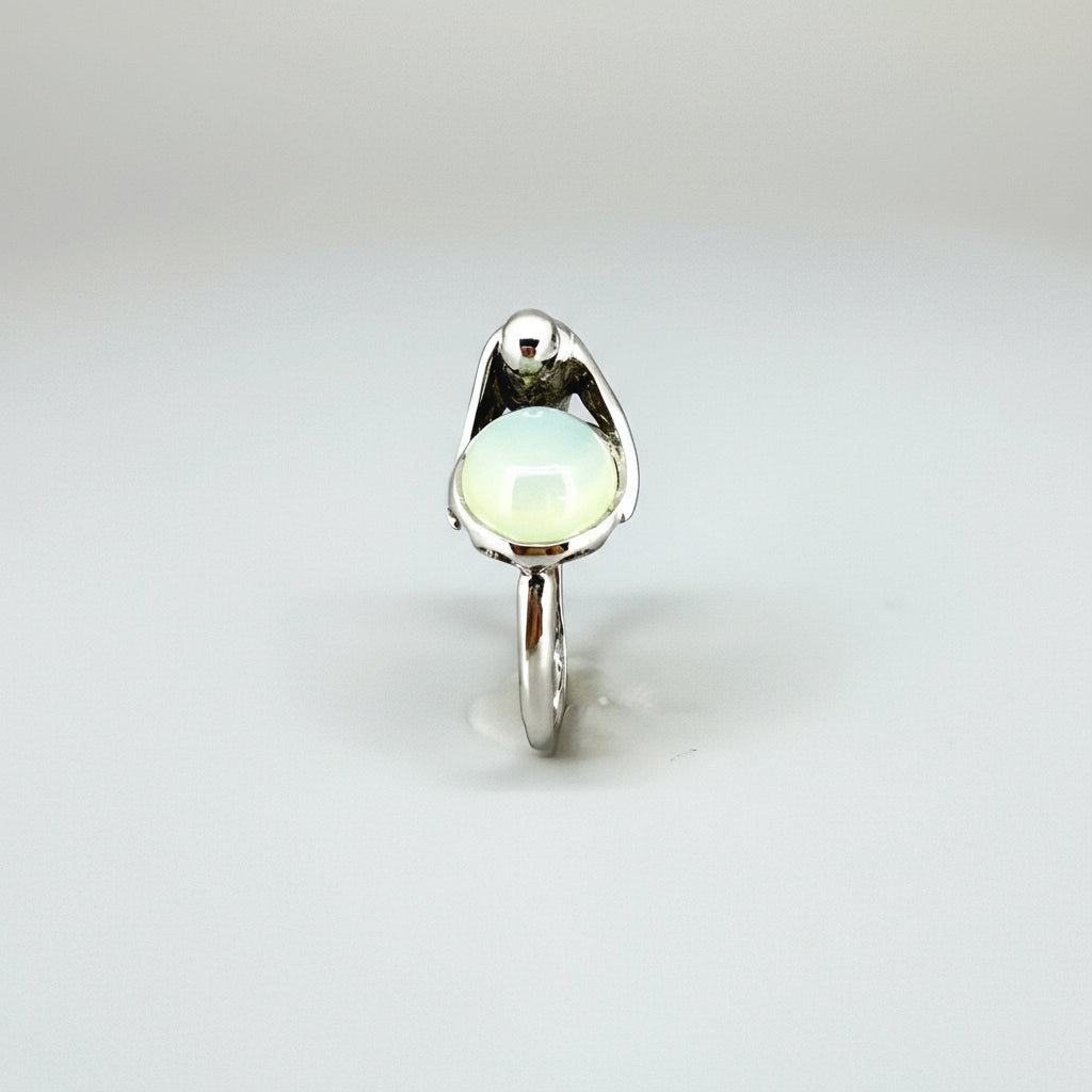 Handcrafted sterling silver ring with bird motif, featuring a 4.76 ct chalcedony cabochon resembling water in a fountain.