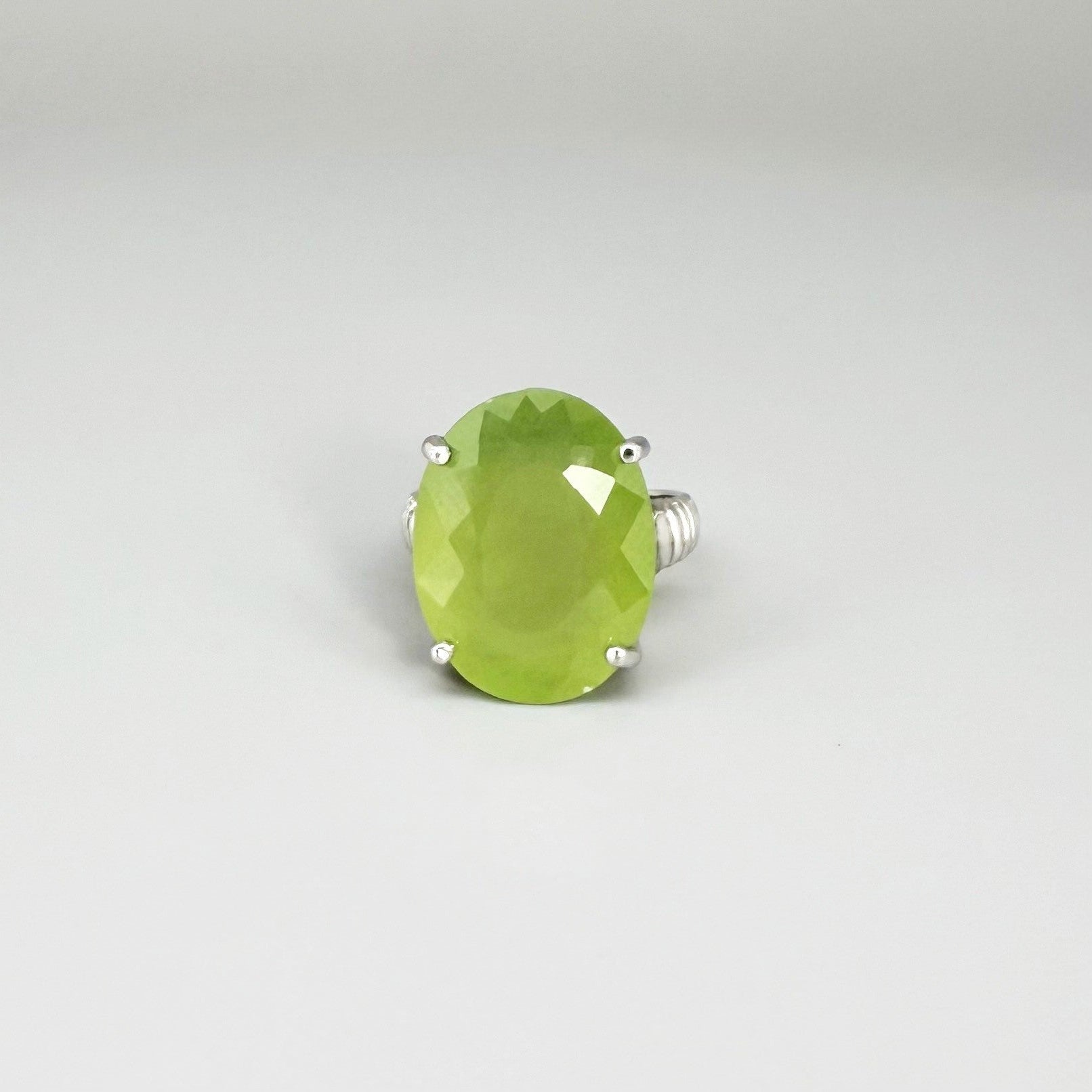 White gold plated sterling silver ring featuring an oval green quartz gemstone, elegant solitaire design with soft natural color.