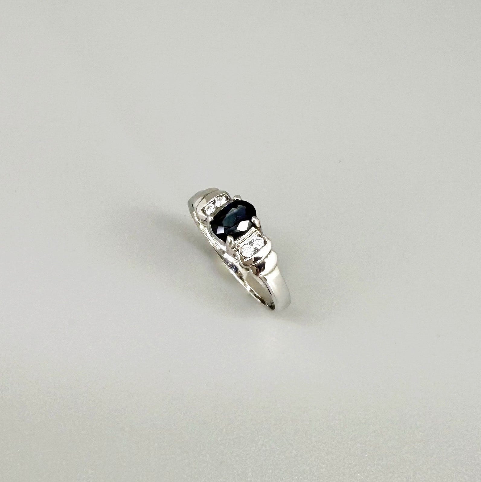 Sapphire and CZ ring in white gold plated sterling silver on neutral background