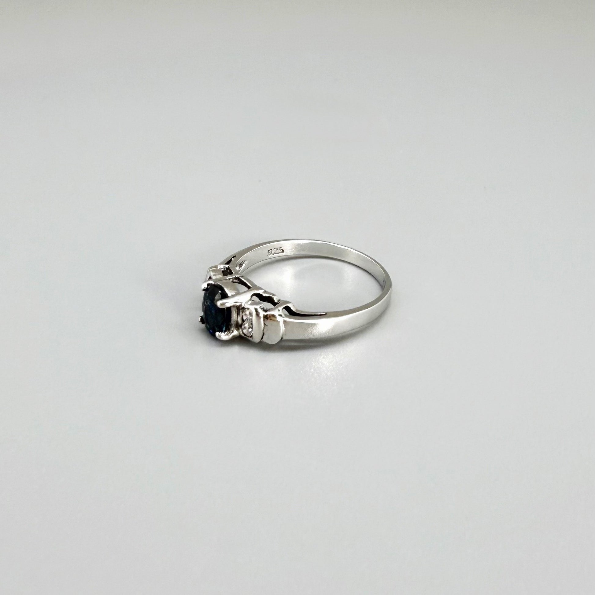 Sapphire and CZ ring in white gold plated sterling silver on neutral background