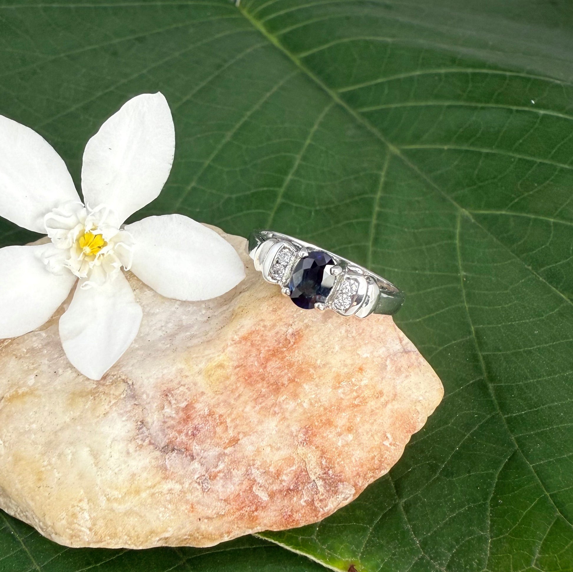 Sapphire and CZ ring in white gold plated sterling silver on neutral background