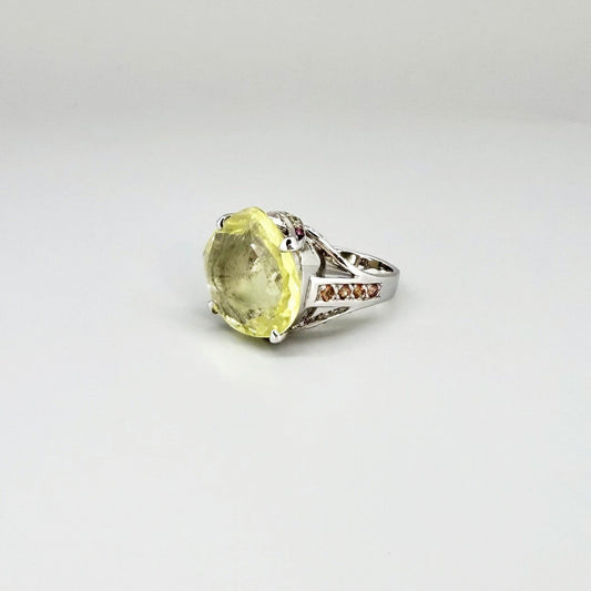 White gold plated sterling silver ring featuring a lemon quartz gemstone surrounded by orange sapphires in a halo design.