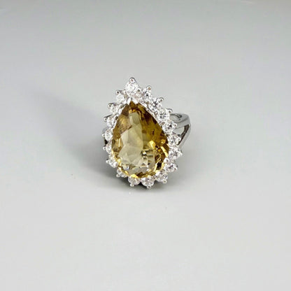 Citrine and CZ ring in white gold plated sterling silver, featuring a pear-shaped golden-yellow gemstone surrounded by clear cubic zirconia halo, elegant and refined design