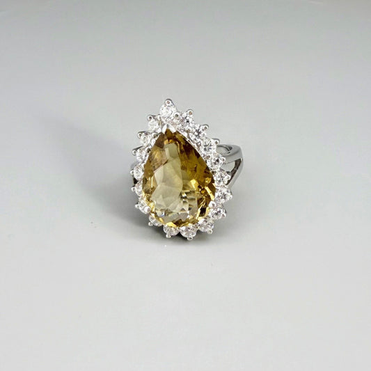 Citrine and CZ ring in white gold plated sterling silver, featuring a pear-shaped golden-yellow gemstone surrounded by clear cubic zirconia halo, elegant and refined design