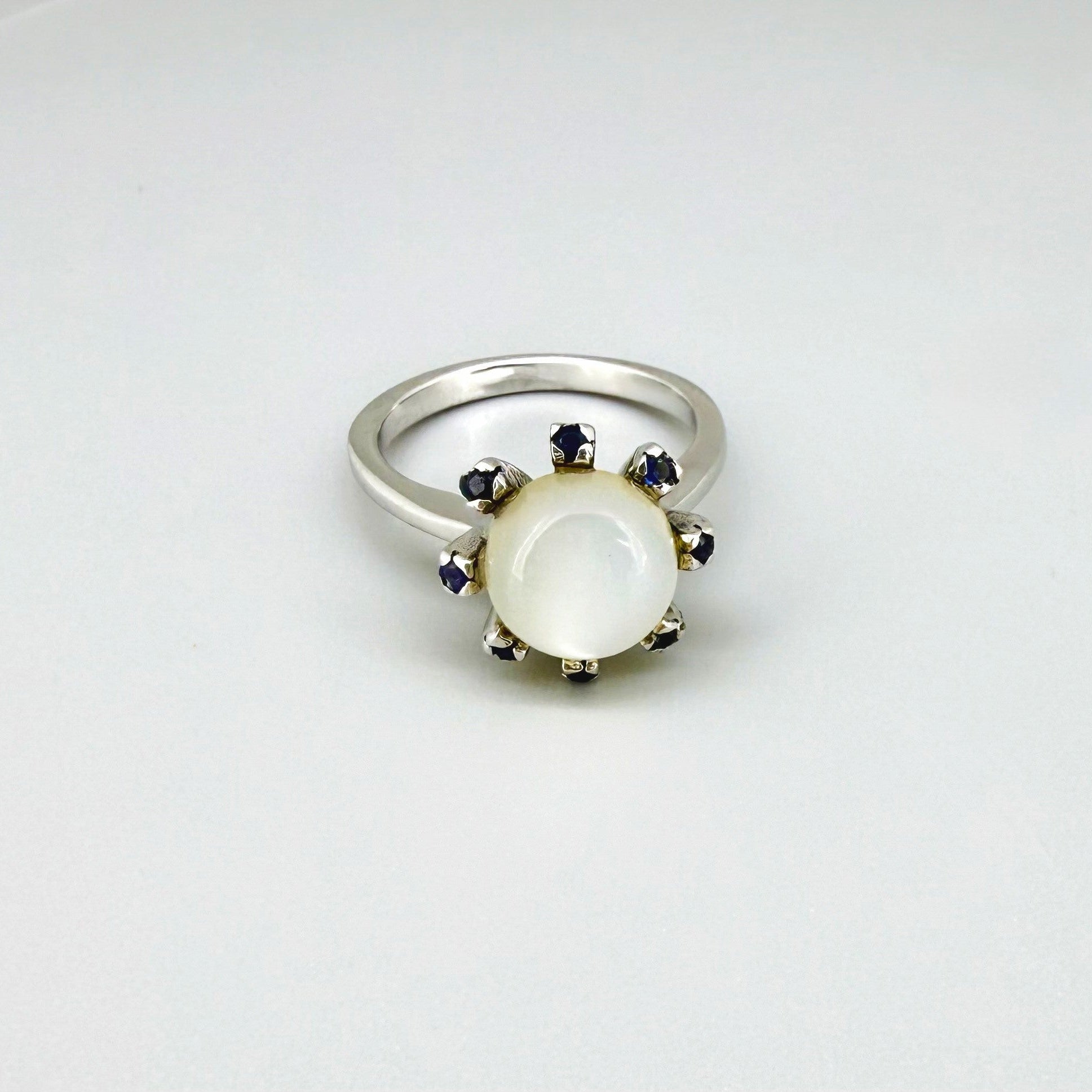 Handmade ring with 3.75 ct natural moonstone and 0.35 ct blue sapphires, set in white-gold-plated sterling silver.