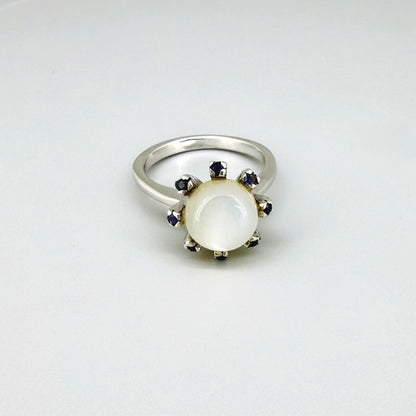 Handmade ring with 3.75 ct natural moonstone and 0.35 ct blue sapphires, set in white-gold-plated sterling silver.