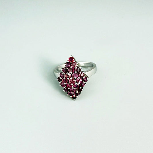 Ruby cluster ring in white gold plated sterling silver, featuring multiple faceted natural rubies in geometric design, elegant and radiant look.