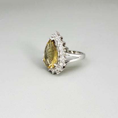 Citrine and CZ ring in white gold plated sterling silver, featuring a pear-shaped golden-yellow gemstone surrounded by clear cubic zirconia halo, elegant and refined design