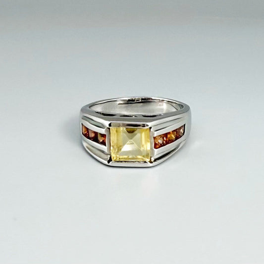 Citrine and sapphire ring in white gold plated sterling silver, featuring a rectangular golden-yellow gemstone flanked by orange sapphires, elegant and timeless design.