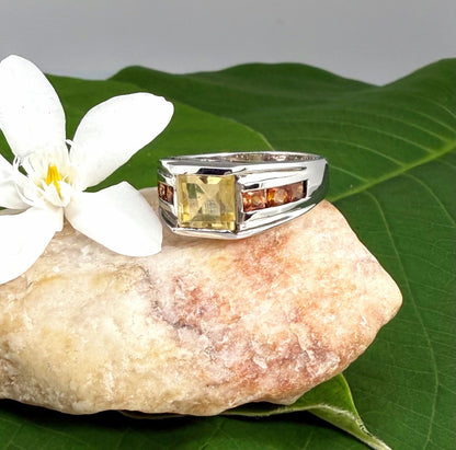 Citrine and sapphire ring in white gold plated sterling silver, featuring a rectangular golden-yellow gemstone flanked by orange sapphires, elegant and timeless design.