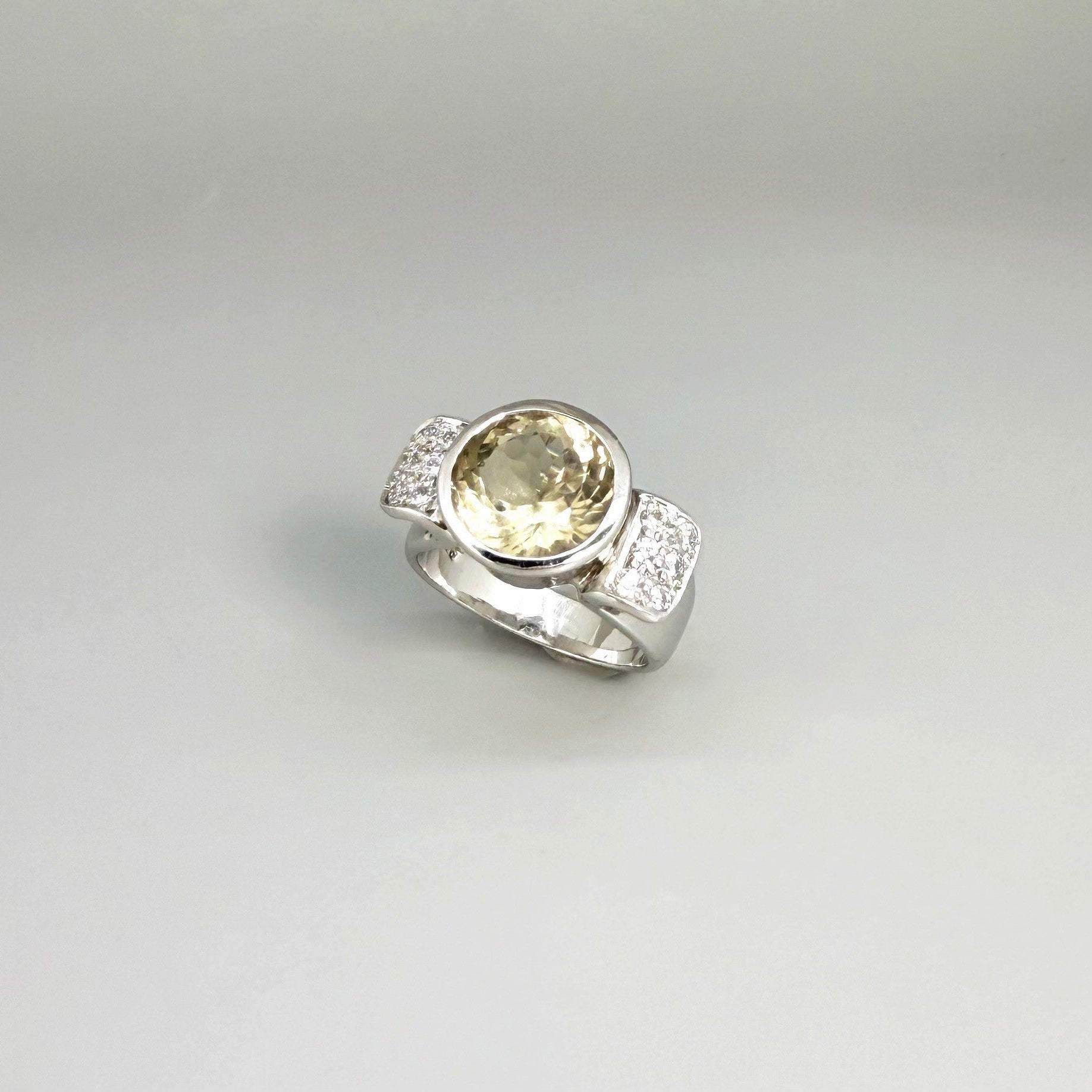 Citrine and CZ ring in white gold plated sterling silver, featuring a faceted golden gemstone with sparkling accents along the band, elegant and radiant design.