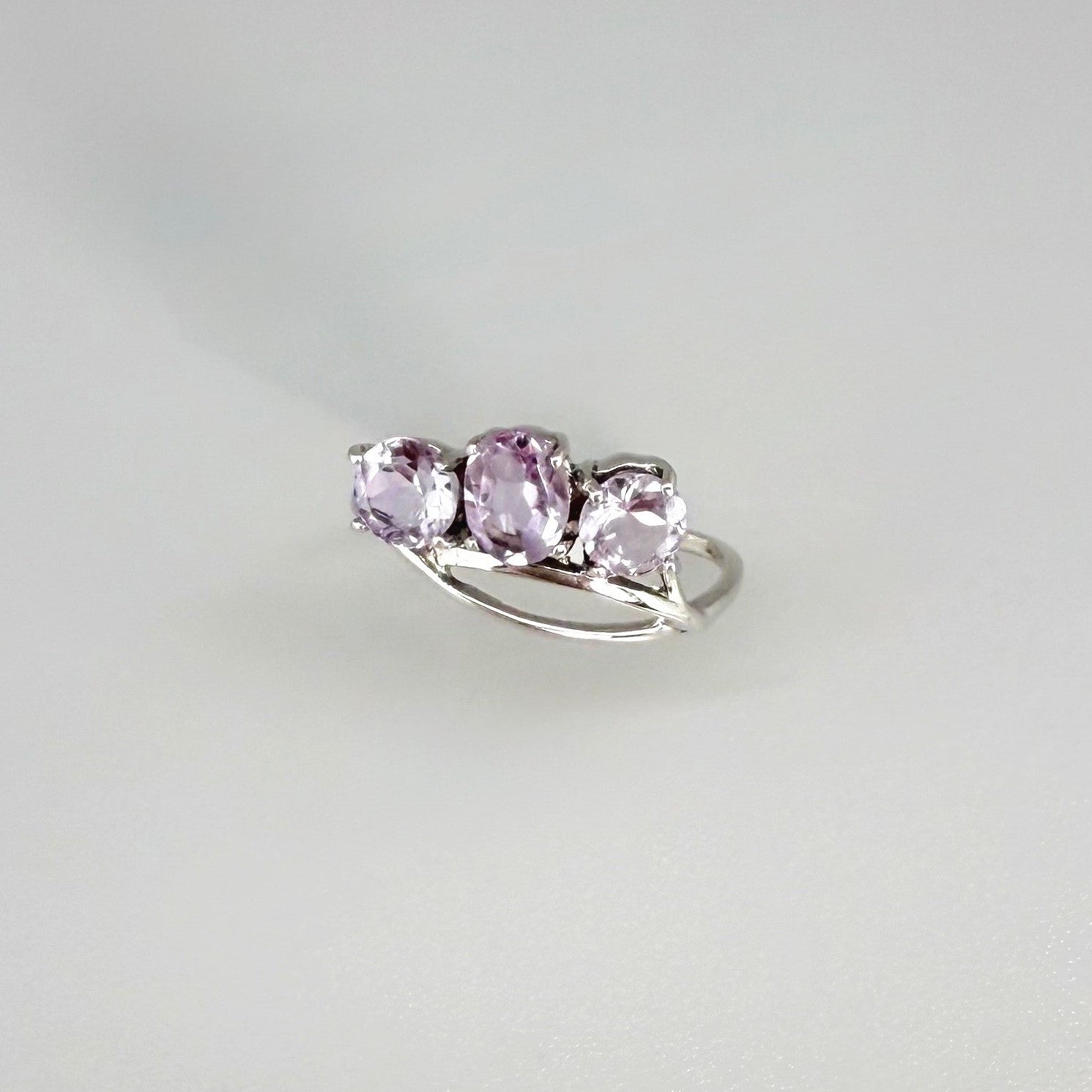 Three-stone amethyst ring in white gold plated sterling silver, featuring natural violet gemstones with soft lavender brilliance, elegant and feminine design.