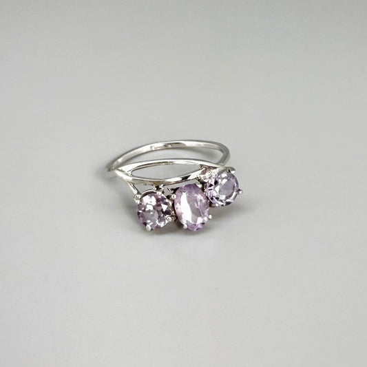 Three-stone amethyst ring in white gold plated sterling silver, featuring natural violet gemstones with soft lavender brilliance, elegant and feminine design.