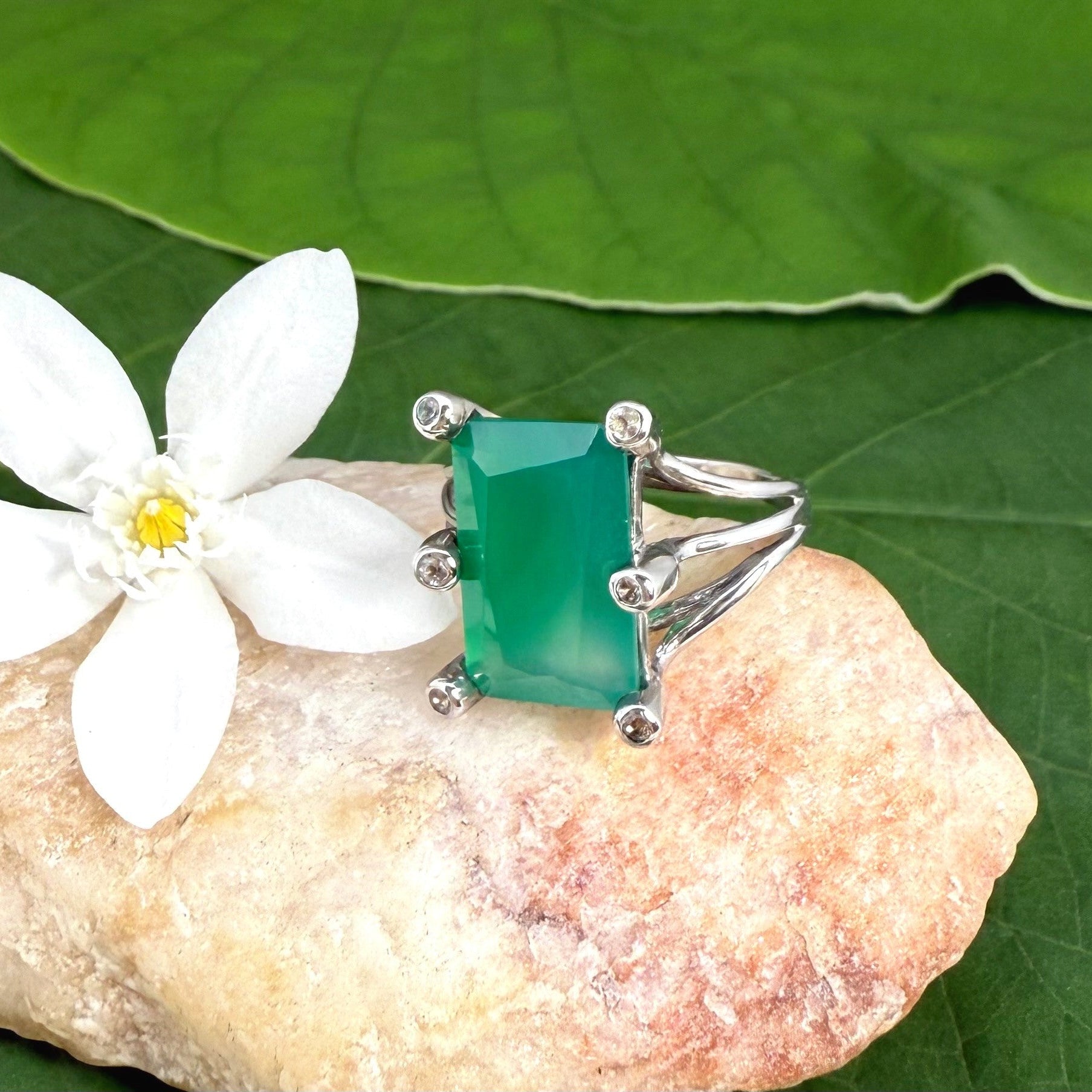 White gold plated sterling silver ring with emerald-cut green chalcedony, elegant solitaire design with soft natural glow.