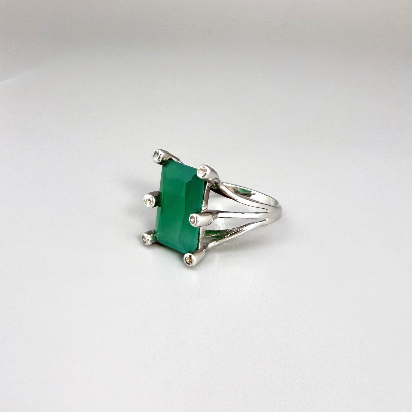 White gold plated sterling silver ring with emerald-cut green chalcedony, elegant solitaire design with soft natural glow.