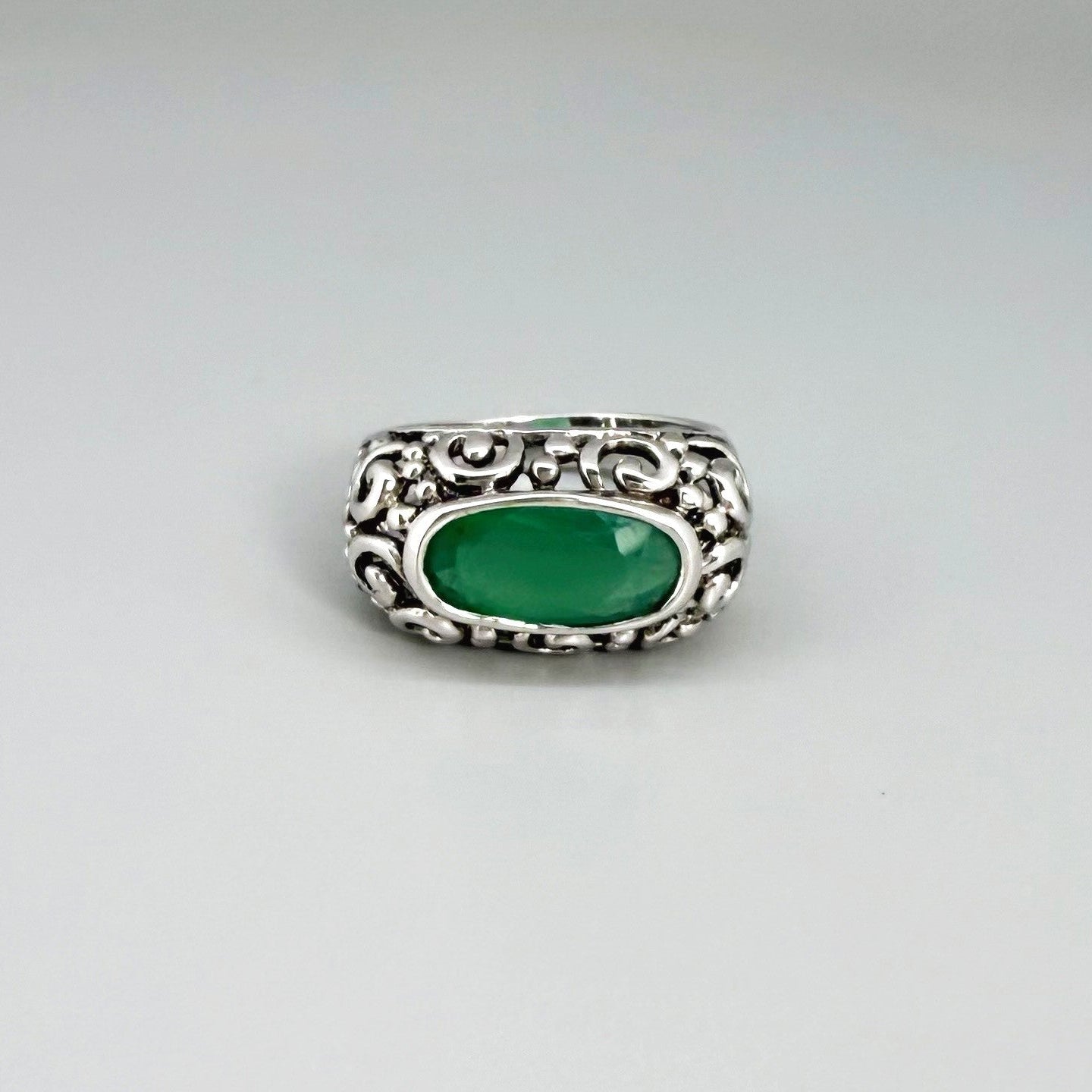 White gold plated sterling silver ring featuring an oval green chalcedony gemstone in a textured silver band.