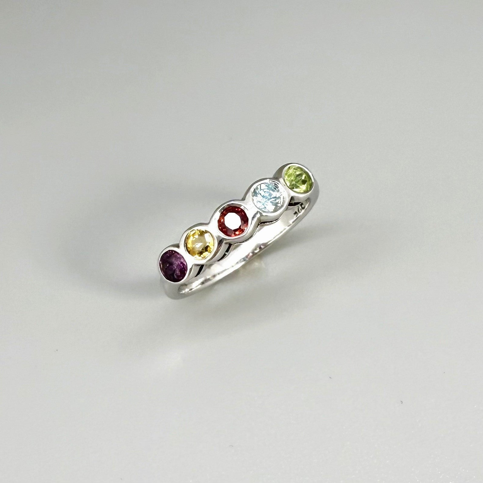 Multicolor gemstone ring in white gold plated sterling silver featuring citrine, tourmaline, rhodolite, and topaz, elegant band design with warm and cool tones.
