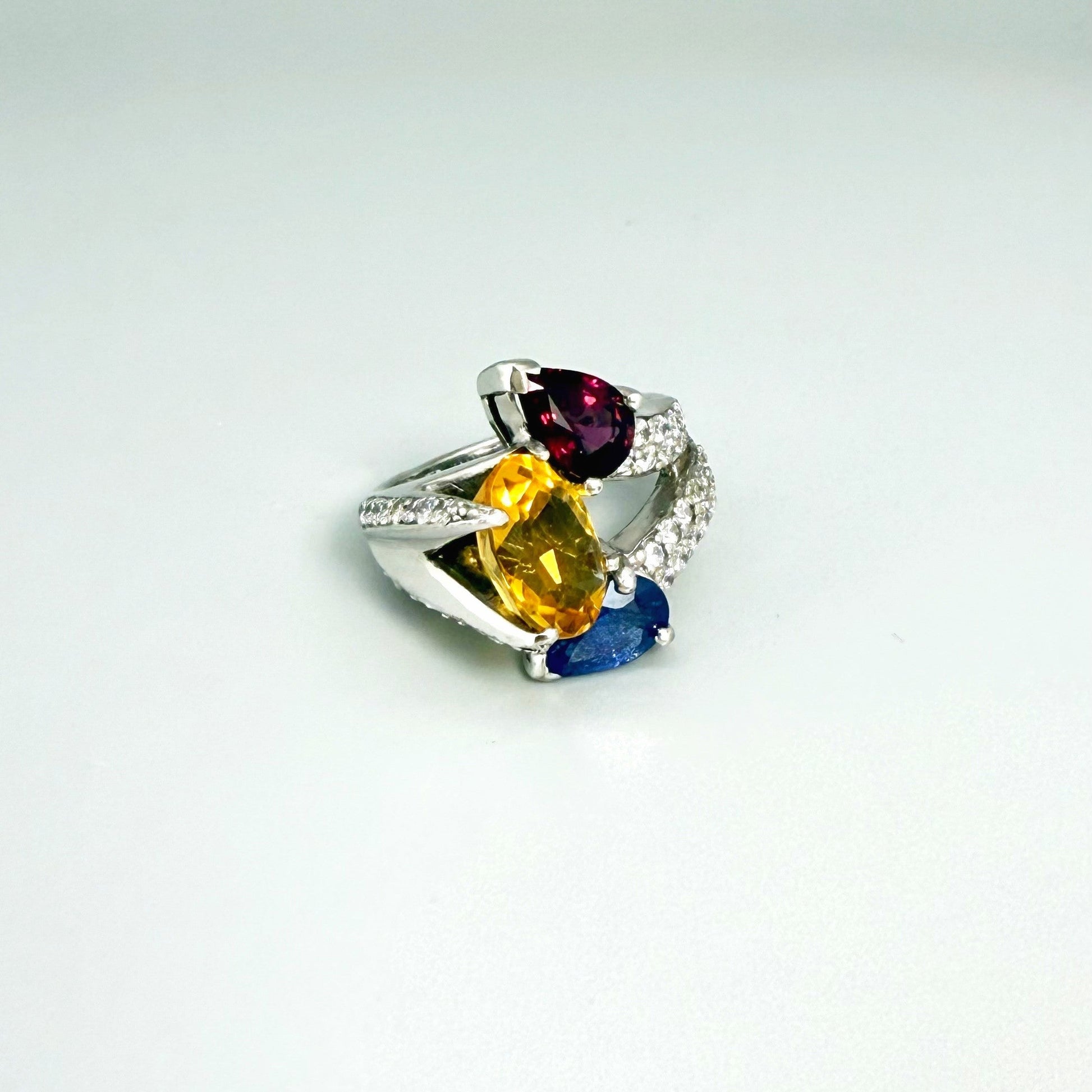 Sapphire, citrine, and rhodolite ring in white gold plated sterling silver, framed with sparkling cubic zirconia, featuring vivid natural gemstones in elegant design.
