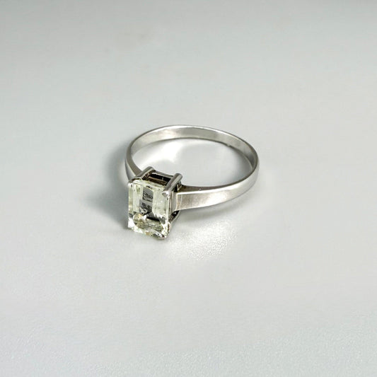 Aquamarine solitaire ring in white gold plated sterling silver, featuring a light blue natural gemstone on neutral background, elegant and timeless design.