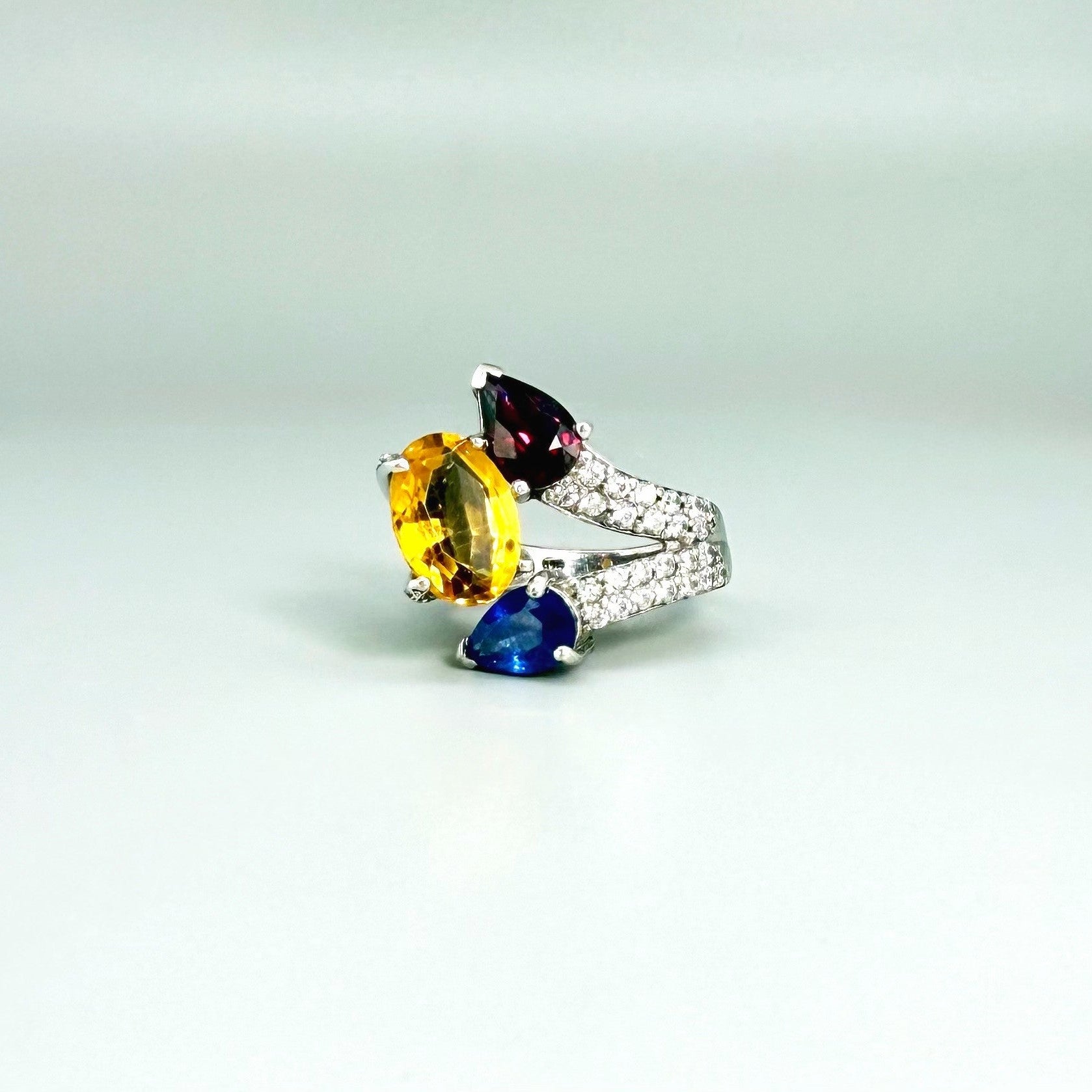 Sapphire, citrine, and rhodolite ring in white gold plated sterling silver, framed with sparkling cubic zirconia, featuring vivid natural gemstones in elegant design.